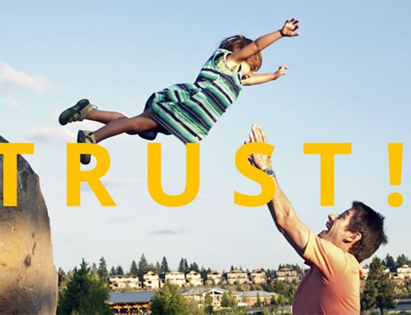 Symbolbild für Vertrauen: Ein Mann fängt ein kleines Mädchen auf