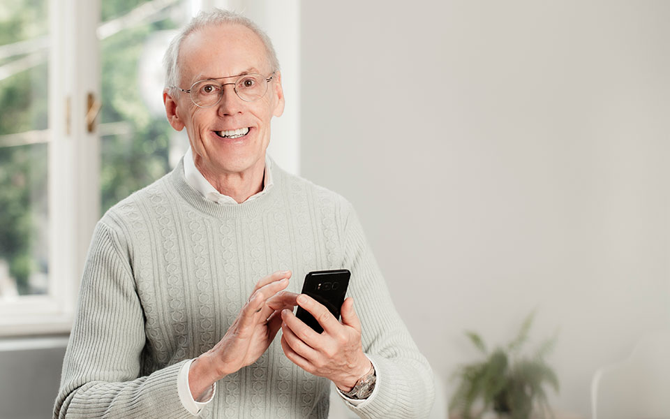 Portrait of Rudolf Vogl working on his smartphone